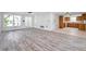 Open layout living room connects to a cozy kitchen, featuring sleek floors and large windows at 9005 Lido Ln, Port Richey, FL 34668