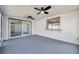 A screened-in patio offers bright natural light, ceiling fans, and modern gray flooring at 9005 Lido Ln, Port Richey, FL 34668