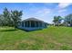 Beautifully maintained lawn with mature landscaping, features a screened lanai perfect for outdoor relaxation at 9251 Geneva St, Spring Hill, FL 34608
