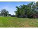 Well-maintained backyard with mature trees and a wooden fence creating a private, serene outdoor space at 9251 Geneva St, Spring Hill, FL 34608