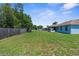 Expansive, grassy backyard offers ample space for recreation and gardening, enclosed by a wooden fence at 9251 Geneva St, Spring Hill, FL 34608