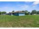A large backyard displays lush lawn, bordered by mature trees, enhancing privacy and outdoor enjoyment at 9251 Geneva St, Spring Hill, FL 34608