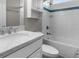 Bathroom features a white vanity, white tub/shower combo with blue accent tile and storage at 9251 Geneva St, Spring Hill, FL 34608