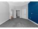 A bedroom with a blue accent wall, grey carpet and access to two walk in closets at 9251 Geneva St, Spring Hill, FL 34608