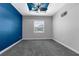 An unfurnished bedroom featuring a blue accent wall, grey carpet and a ceiling fan at 9251 Geneva St, Spring Hill, FL 34608