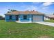 Charming blue single-story home featuring a well-manicured lawn and a two-car garage at 9251 Geneva St, Spring Hill, FL 34608