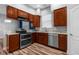 This kitchen features wood cabinets, stainless steel appliances, granite countertops and plank flooring at 9251 Geneva St, Spring Hill, FL 34608