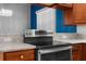 Close up of a stainless steel oven in a kitchen with granite countertops and cherry wood cabinets at 9251 Geneva St, Spring Hill, FL 34608