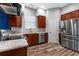This kitchen features wood cabinets, stainless steel appliances, granite countertops and plank flooring at 9251 Geneva St, Spring Hill, FL 34608