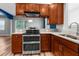 This kitchen features wood cabinets, stainless steel appliances, granite countertops and plank flooring at 9251 Geneva St, Spring Hill, FL 34608