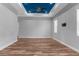 Large, bright living room featuring hardwood floors, a dark blue tray ceiling, and neutral decor at 9251 Geneva St, Spring Hill, FL 34608