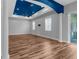 Expansive living room with hardwood floors, white pillars, and sliding glass door to the patio at 9251 Geneva St, Spring Hill, FL 34608