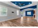 Open-concept living space with hardwood floors, grey walls, and a striking blue tray ceiling at 9251 Geneva St, Spring Hill, FL 34608