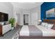 Main bedroom with a blue accent wall, grey carpet and access to two walk in closets at 9251 Geneva St, Spring Hill, FL 34608