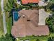 Aerial shot showcases the home's roof, pool, and backyard with mature landscaping at 9933 Milano Dr, Trinity, FL 34655