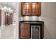 Bar area features rich wood cabinets, a granite countertop, and a wine cooler at 9933 Milano Dr, Trinity, FL 34655