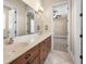 Spacious bathroom featuring a double vanity with dark wood cabinets and an open doorway to the bedroom at 9933 Milano Dr, Trinity, FL 34655