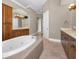 Elegant bathroom features a garden tub, separate vanities with wood cabinets and beautiful tile flooring at 9933 Milano Dr, Trinity, FL 34655
