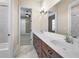 Bright bathroom featuring a dual sink vanity with wood cabinets and access to the bathtub and bedrooms at 9933 Milano Dr, Trinity, FL 34655