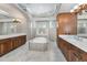 Luxurious bathroom with a soaking tub, separate vanities, and tile flooring at 9933 Milano Dr, Trinity, FL 34655