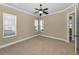 Bright bedroom featuring neutral walls, carpet, ceiling fan, and ample natural light from two windows at 9933 Milano Dr, Trinity, FL 34655