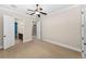Spacious bedroom with neutral carpeting, ceiling fan, and attached bathroom at 9933 Milano Dr, Trinity, FL 34655