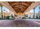 Grand entrance to the clubhouse with brick pavers, a portico with wood beams, and lush landscaping at 9933 Milano Dr, Trinity, FL 34655