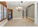 Elegant dining room with a beautiful chandelier, tile floors, and a large window at 9933 Milano Dr, Trinity, FL 34655