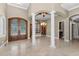 Grand foyer with decorative columns, tile flooring, and a view into the dining and living areas at 9933 Milano Dr, Trinity, FL 34655