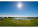 Picturesque golf course view with a vibrant green putting green and a scenic lake under a sunny sky at 9933 Milano Dr, Trinity, FL 34655
