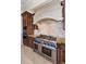 Chef's kitchen with a stone hood, stainless steel range, and custom cabinetry at 9933 Milano Dr, Trinity, FL 34655