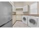 Well-equipped laundry room with modern washer, dryer, sink, and plenty of cabinet space at 9933 Milano Dr, Trinity, FL 34655