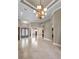 Expansive living area featuring tile floors, tray ceilings, an elegant chandelier, and column details at 9933 Milano Dr, Trinity, FL 34655