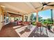 Inviting covered patio with comfortable seating, brick flooring, columns, and views of lush landscape at 9933 Milano Dr, Trinity, FL 34655