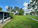 This backyard offers a green lawn, shed, and chain link fence creating an inviting outdoor space at 10014 Kingswood Ln, Port Richey, FL 34668