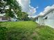 This backyard features a large grassy area, shed, and is enclosed by a chain link fence at 10014 Kingswood Ln, Port Richey, FL 34668