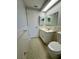 This bathroom features a vanity with a mirror and shelving, toilet, and a clean, well-lit space at 10014 Kingswood Ln, Port Richey, FL 34668