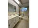 This bathroom features a vanity with a mirror, toilet, and a sliding glass door for the shower and tub at 10014 Kingswood Ln, Port Richey, FL 34668