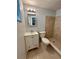 This bathroom features a sleek white vanity, toilet, and a tiled shower with updated fixtures at 10014 Kingswood Ln, Port Richey, FL 34668