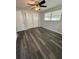 Bedroom with new flooring, a ceiling fan, and a large window for natural light at 10014 Kingswood Ln, Port Richey, FL 34668