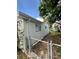 View of the home's exterior with a chain link fence surrounding the property and a clear blue sky at 10014 Kingswood Ln, Port Richey, FL 34668