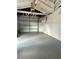 Spacious garage featuring an overhead door, ample space for vehicles, and white-painted wood support beams at 10014 Kingswood Ln, Port Richey, FL 34668