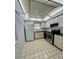 Well-lit kitchen featuring white cabinets, a stainless steel oven, and light tile flooring at 10014 Kingswood Ln, Port Richey, FL 34668