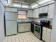 Efficient kitchen with stainless steel oven, white cabinets, and tiled flooring at 10014 Kingswood Ln, Port Richey, FL 34668