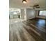 Living room featuring modern flooring, a ceiling fan, and an open view to the kitchen at 10014 Kingswood Ln, Port Richey, FL 34668