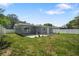 View of backyard with patio, potted plants and grill against grey house siding surrounded by white fence at 1004 Peninsula Ave, Tarpon Springs, FL 34689