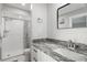 Bathroom features updated vanity with granite counters and tiled shower at 1004 Peninsula Ave, Tarpon Springs, FL 34689