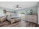 Light-filled bedroom with a ceiling fan, dresser, and large window at 1004 Peninsula Ave, Tarpon Springs, FL 34689