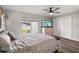 Bright bedroom with a ceiling fan, dresser, and large window with back yard view at 1004 Peninsula Ave, Tarpon Springs, FL 34689