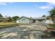 Charming single-story home with a well-maintained lawn, long driveway and decorative landscaping at 1004 Peninsula Ave, Tarpon Springs, FL 34689